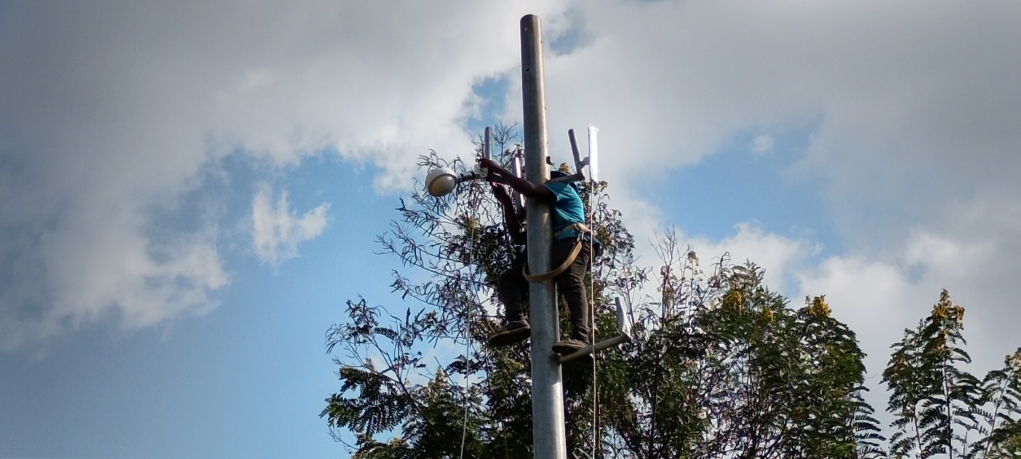 Technician mounting a wireless access point on a pole